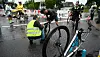 Poliser och räddningspersonal vid en cykelolycka på en regnig gata med avspärrningar och cykel i förgrunden.