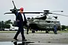 Donald Trump gengur yfir flugbraut fyrir framan herþyrlur.