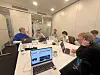 Journalists in Hamburger Morgenpost and Labrador CMS employees gathered around a conference table with laptops during a workshop.