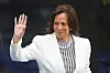 Kamala Harris waves in a white blazer and striped blouse at the Obama Presidential Center dedication ceremony.