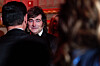 Javier Milei faces the camera while greeting attendees at a crowded indoor gala.
